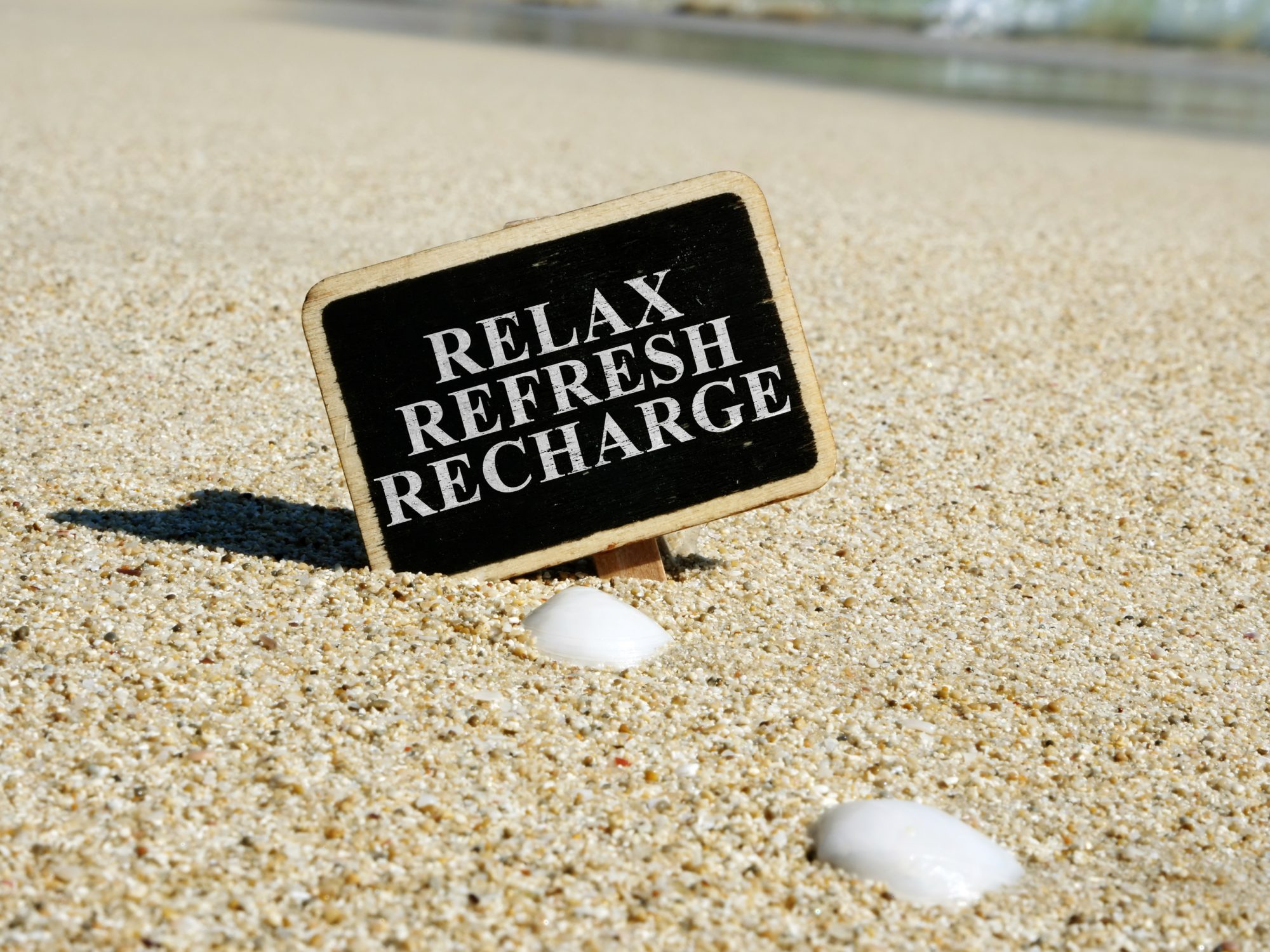 Relax refresh recharge sign on a beach