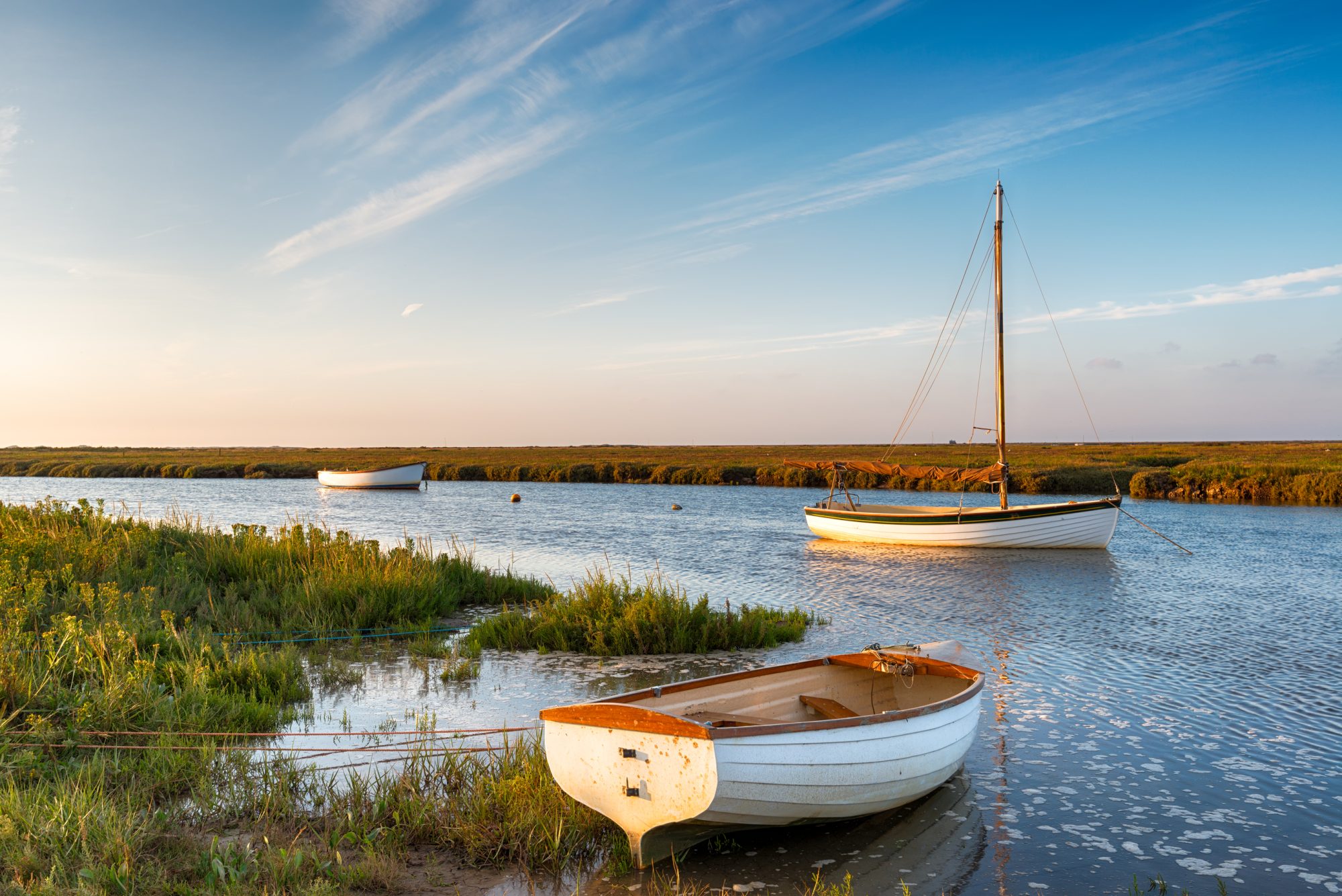Boats at high tide on salt marshes at Blakeney on the north Norfolk coast